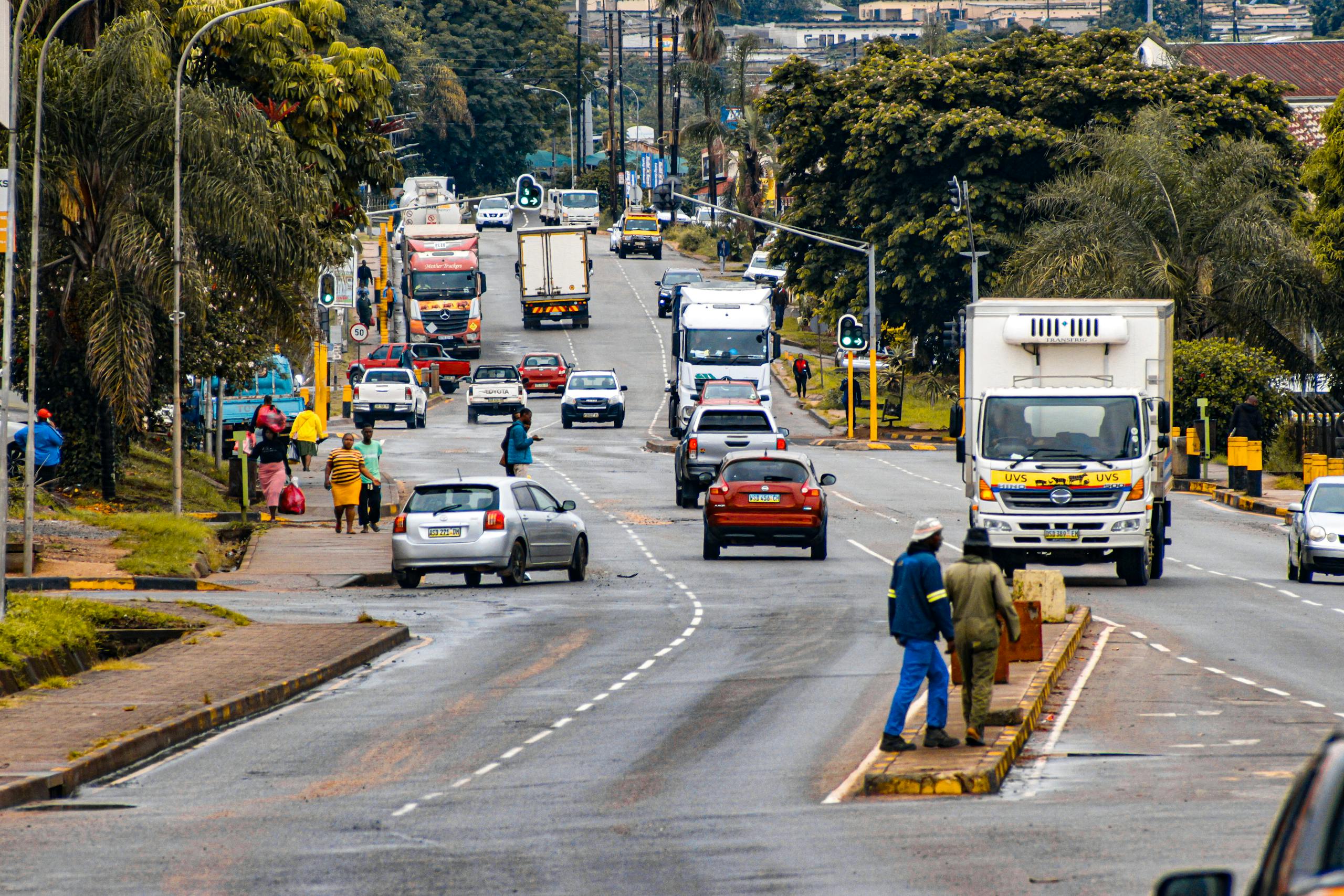 A lively street scene depicting traffic and pedestrians in Bhunya, Eswatini.