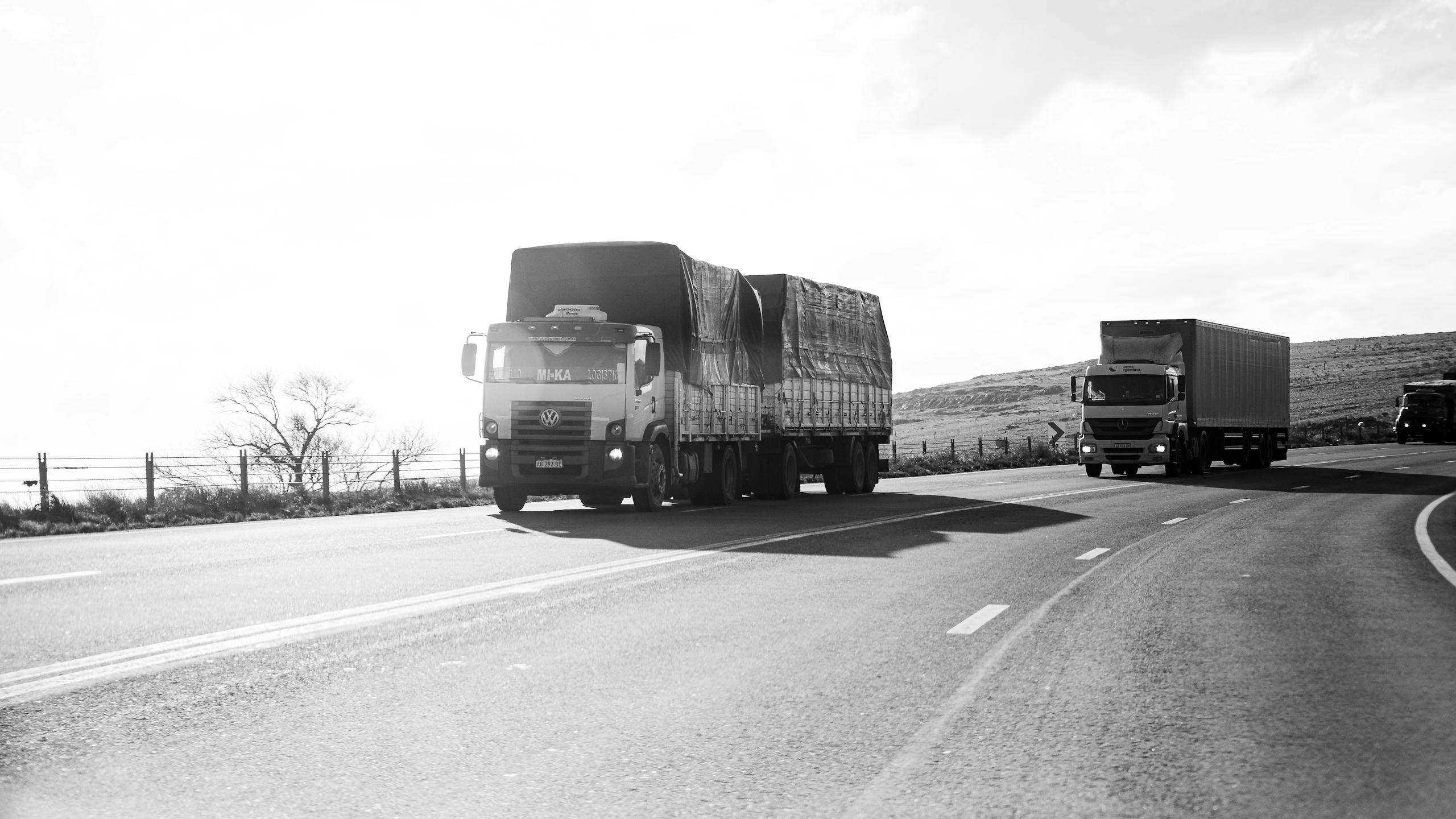 Monochrome shot of trucks on a highway in Buenos Aires, Argentina, capturing urban life.
