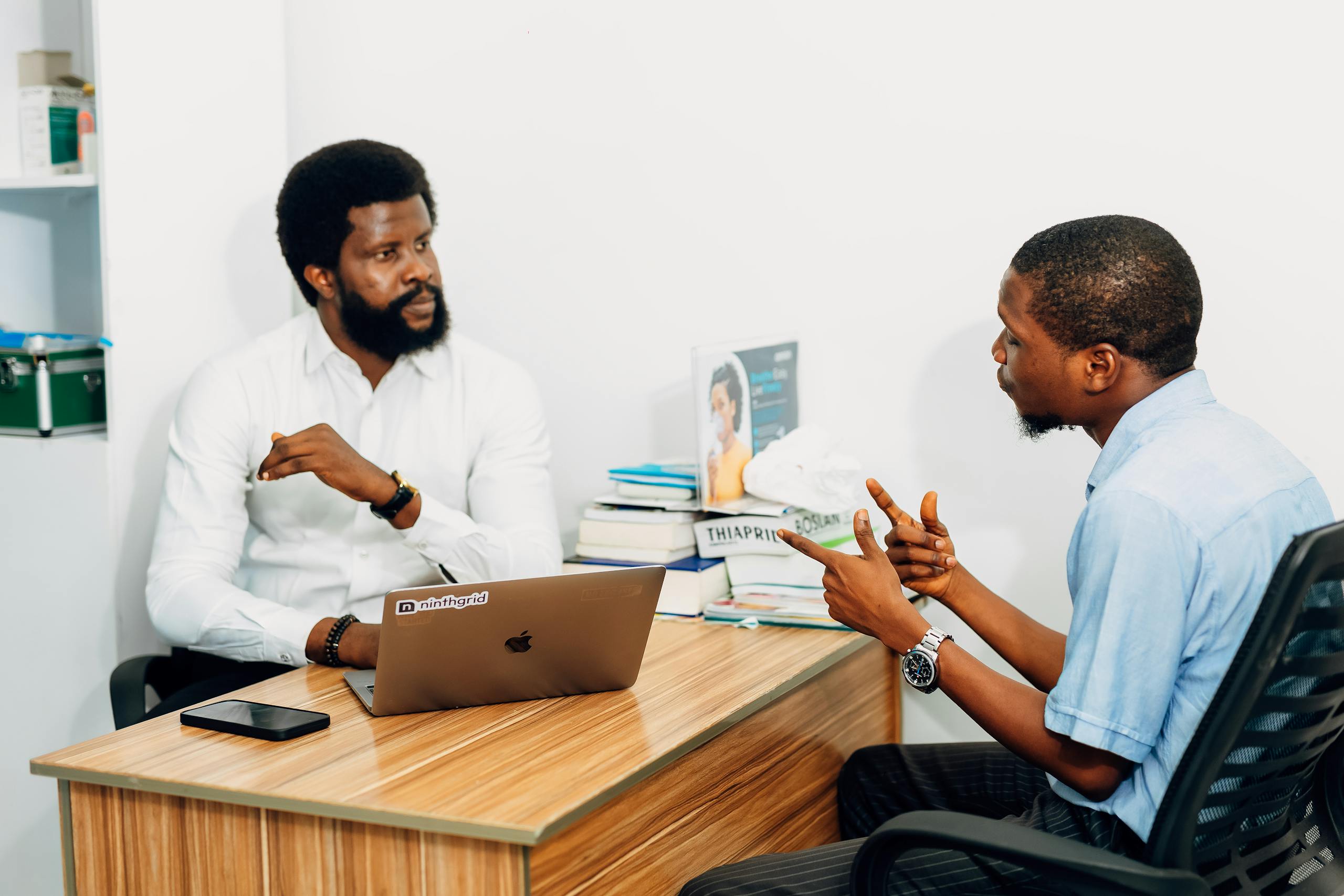 Two adults engaged in a professional consultation in a Lagos office, discussing business or healthcare topics.